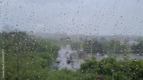Heavy rain in city. Falling rain with blury background. Focus on drops on window