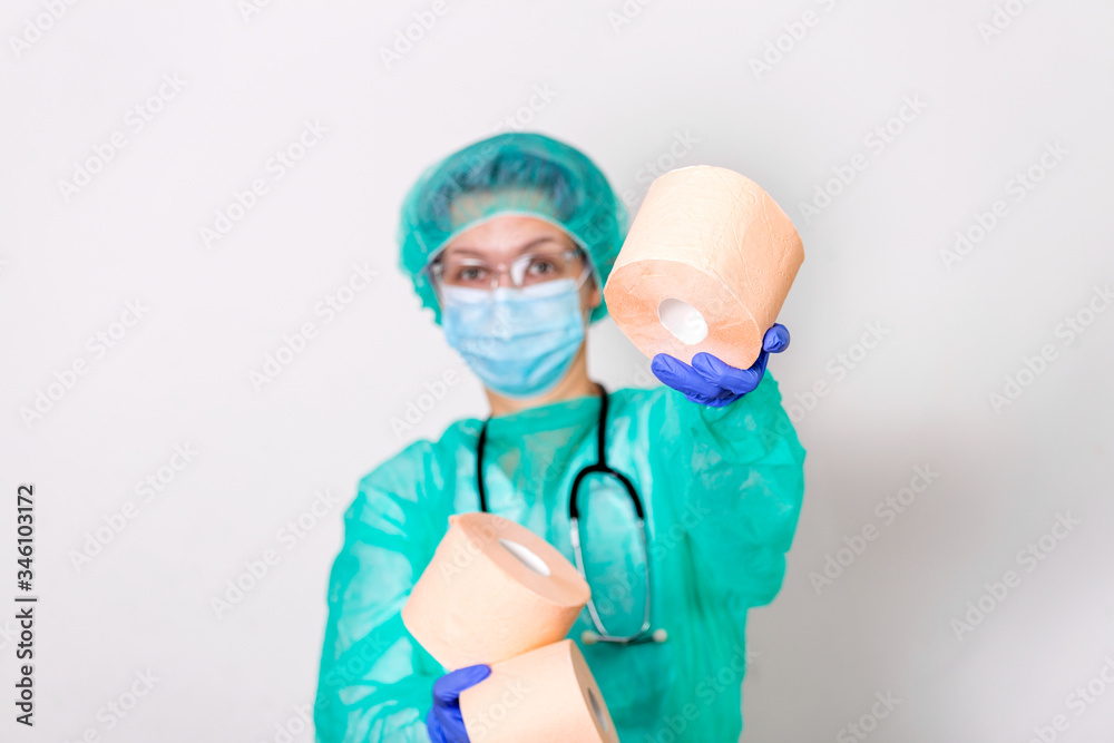 Doctor wearing PPE protection suite or nurse with a stethoscope holds a rolls of toilet paper. Lack of toilet paper in the quarantine of coronavirus, the concept of a shortage of things in stores Doctor wearing PPE protection suite or nurse with a stethoscope holds a rolls of toilet paper. Lack of toilet paper in the quarantine of coronavirus, the concept of a shortage of things in stores