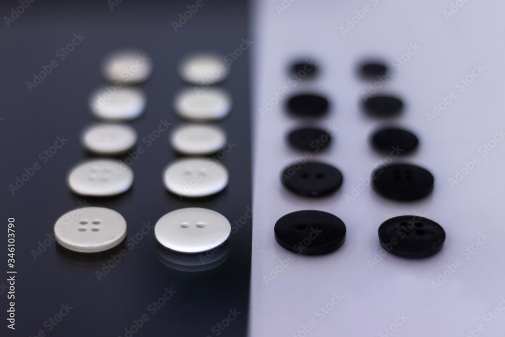 A group of clothing buttons lined up in rows and placed on top of each other to create a contrast A group of clothing buttons lined up in rows and placed on top of each other to create a contrast