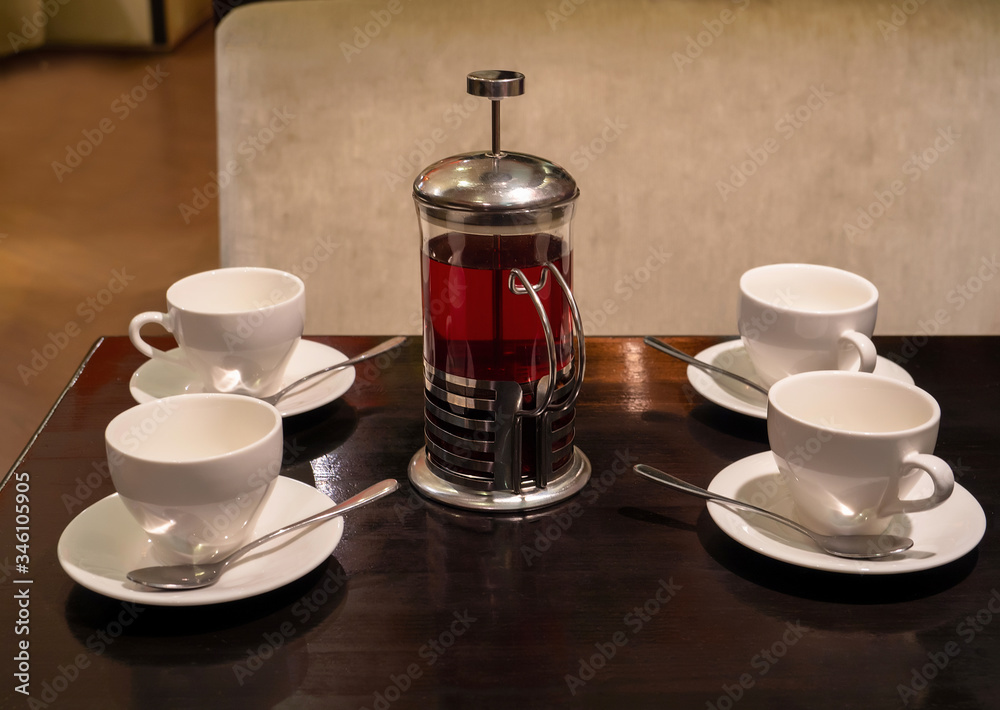 four empty tea cups and a French press are on a wooden table in the cafe. top view
