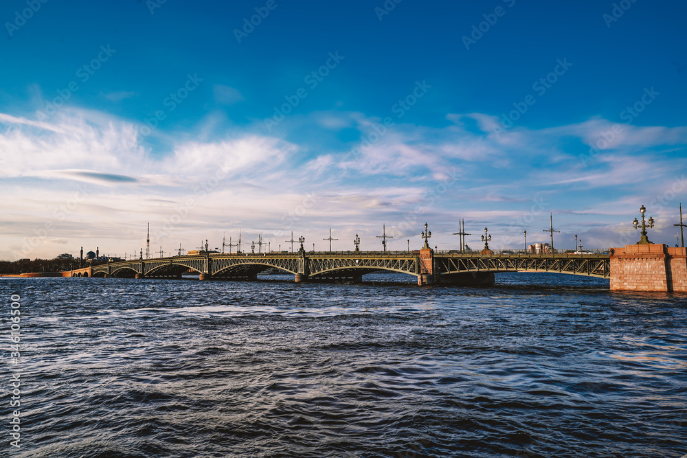 Granite embankment in Saint Petersburg, beautiful orange sun, bright sunset, the Neva river and the Peter and Paul fortress