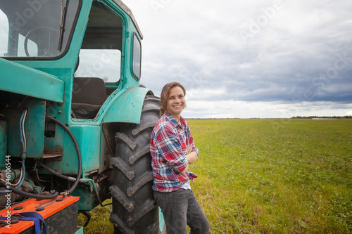 young attractive girl woman working in a field on a tractor, rural profession for young people, rural agriculture business