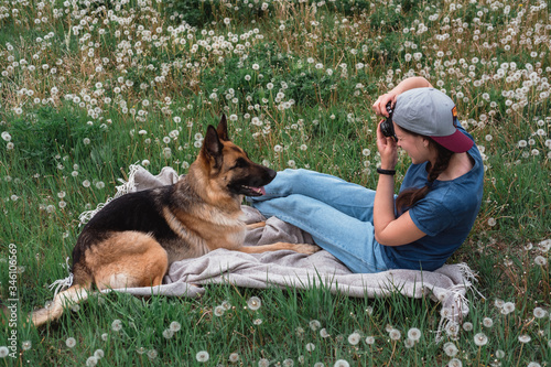 Girl photographer and German shepherd, girl taking pictures of a dog.