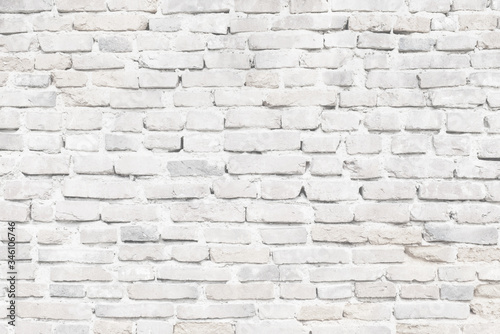Limewashed old brick wall in white texture close-up
