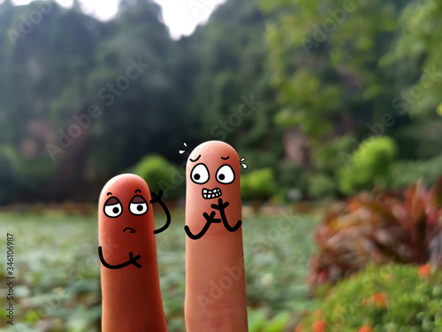 Two fingers are decorated as two person. They have different skin color.