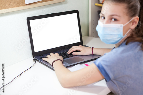 Social distance during quarantine, self-isolation and online education using laptop, girl at the desk