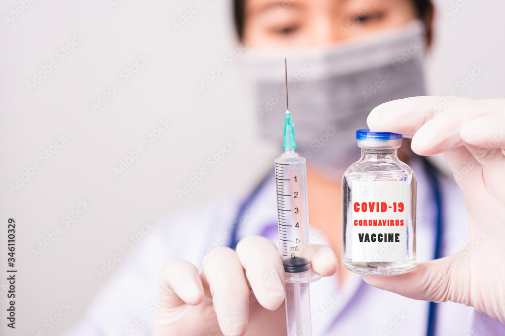 Asian female woman doctor or nurse in uniform and gloves wearing face mask protective in lab hold needle syringe drug and medicine vial vaccine bottle and on bottle has Asian female woman doctor or nurse in uniform and gloves wearing face mask protective in lab hold needle syringe drug and medicine vial vaccine bottle and on bottle has