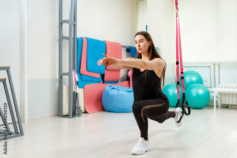 Fototapeta premium Beautiful and strong girl goes in for sports in the gym