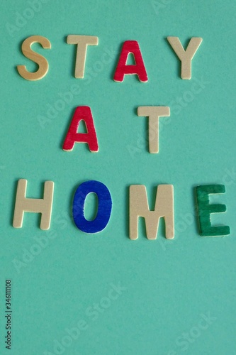 stay at home phrase written in wooden letters on a colored cardboard, coronavirus advertisement