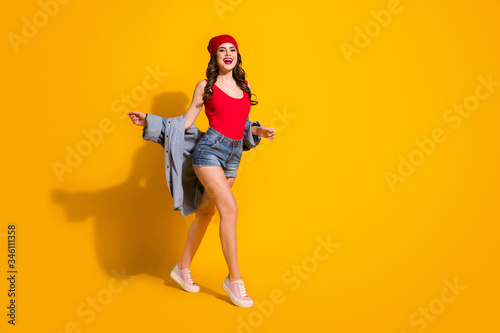 Full length body size view of her she nice-looking attractive slender glamorous cheerful cheery wavy-haired girl walking having fun isolated over bright vivid shine vibrant yellow color background