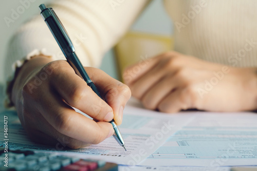 Tax concept.Close up hand filing US tax form. tax form us business income office hand fill concept