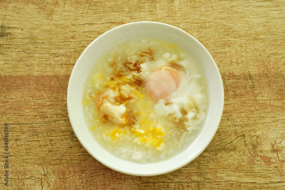 rice porridge with egg yolk dressing sot sauce on bowl rice porridge with egg yolk dressing sot sauce on bowl