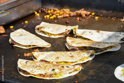 The process of preparing a quesadilla, traditional Mexican dish. Outdoor outside setting photo