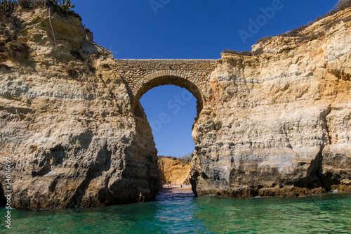 Entrada a la playa desde el mar con un arco de piedra natural en Punta Piedade, Portugal