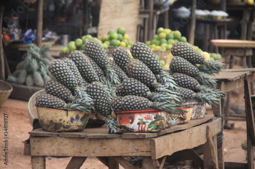 stosy świeżych ananasów ułożonych na straganie przy drodze w afrykańskim miasteczku