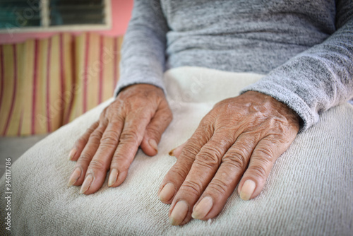 Hand of an old woman withering on his lap