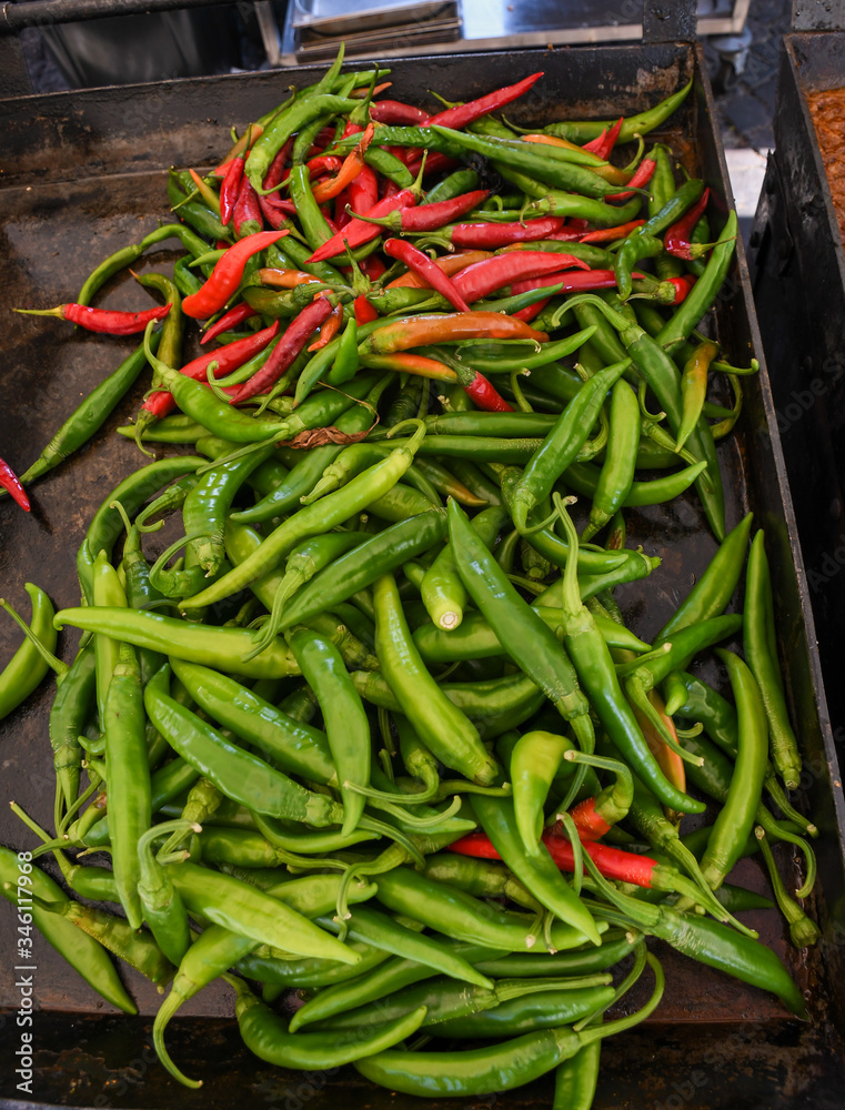 Green and red chili on a counter top of a store during food festival market.