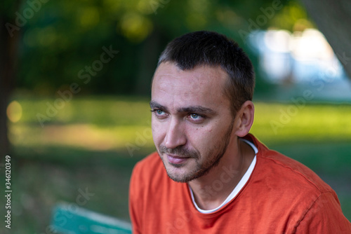 Young man relaxing on park bench on a summers day