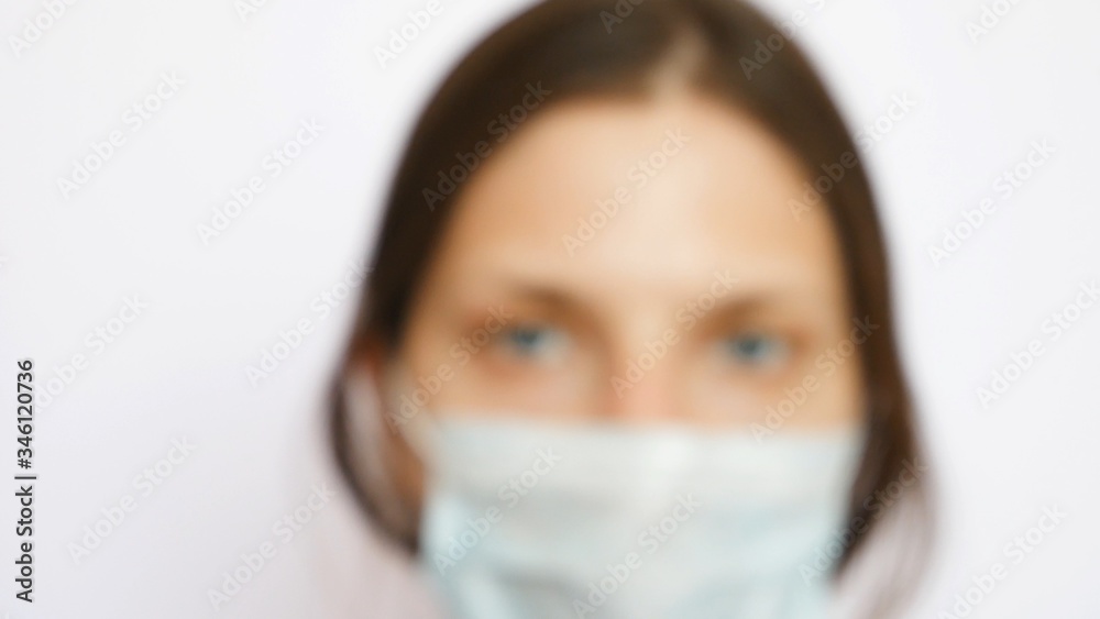 One pretty nurse with a protective mask looks into the distance One pretty nurse with a protective mask looks into the distance