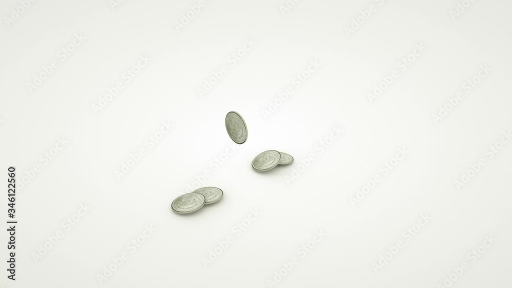 Shiny coins fall on a white table and fly apart in different directions. Shiny coins fall on a white table and fly apart in different directions.