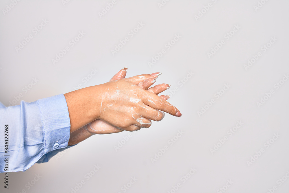 Young caucasian woman cleaning hands using alcohol liquid over isolated white background Young caucasian woman cleaning hands using alcohol liquid over isolated white background