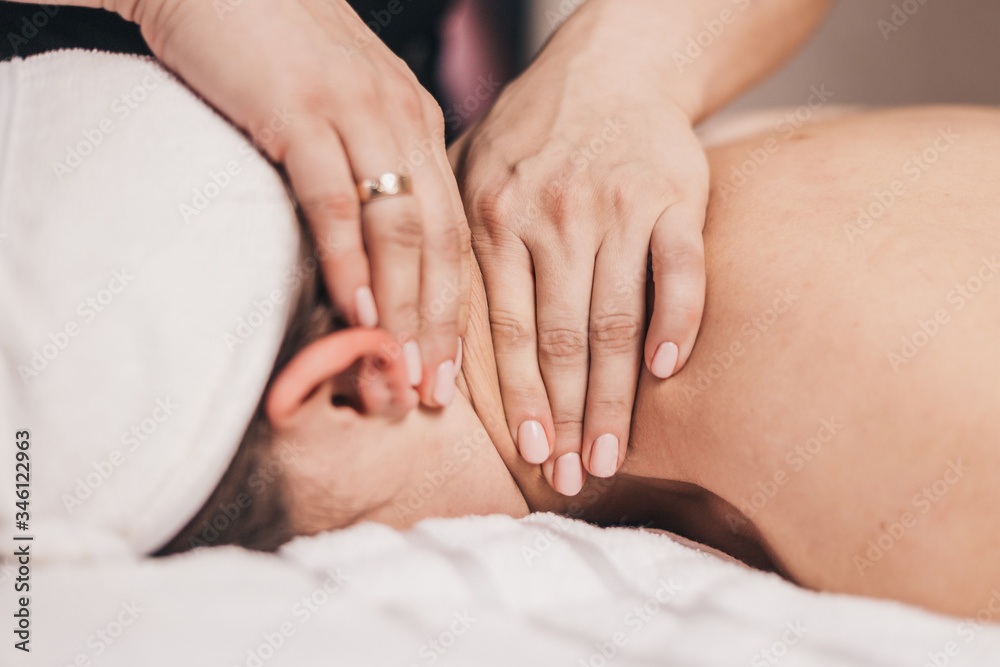 Manual therapy of the cervical spine - hands of a massage therapist of a chiropractor during massage - treatment of osteochondrosis Manual therapy of the cervical spine - hands of a massage therapist of a chiropractor during massage - treatment of osteochondrosis