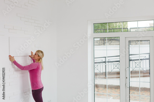 Photo of woman looking at the blank white canvas. Horizontal, mockup