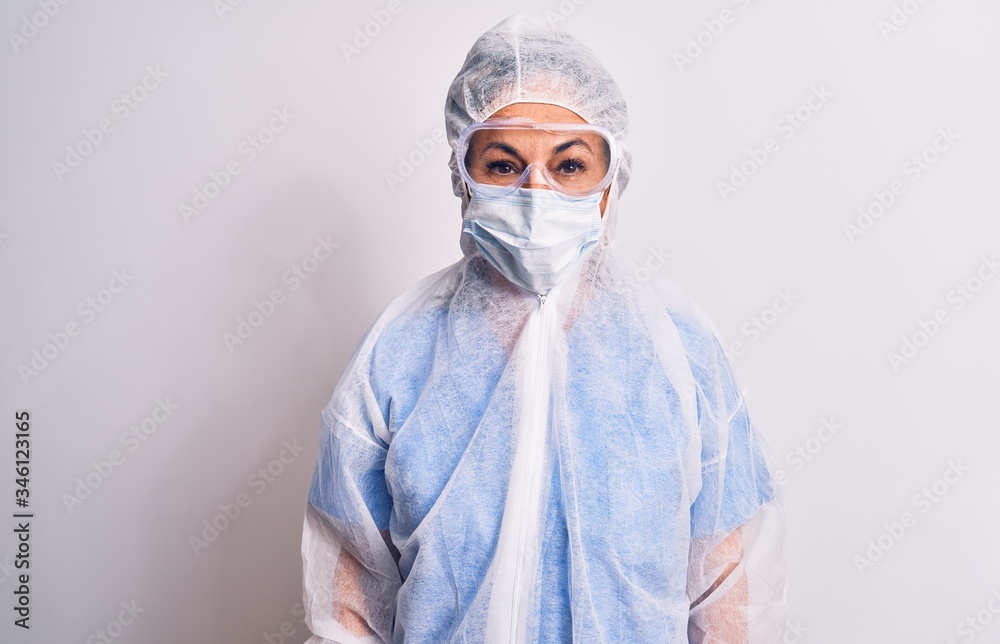 Middle age nurse woman wearing protection coronavirus equipment over white background with a happy and cool smile on face. Lucky person.
