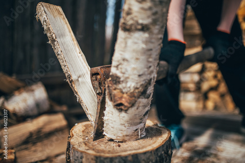 Fototapeta Naklejka Na Ścianę i Meble -  Blow of an ax splits a birch log into two - logging for heating a house
