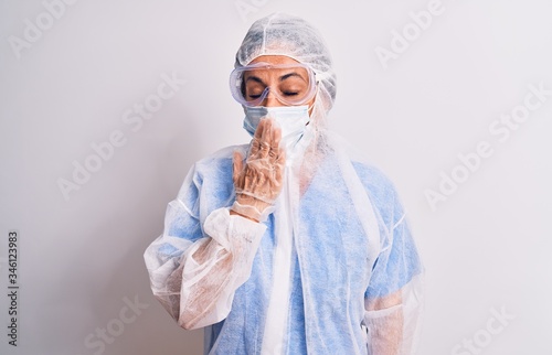 Middle age nurse woman wearing protection coronavirus equipment over white background bored yawning tired covering mouth with hand. Restless and sleepiness.