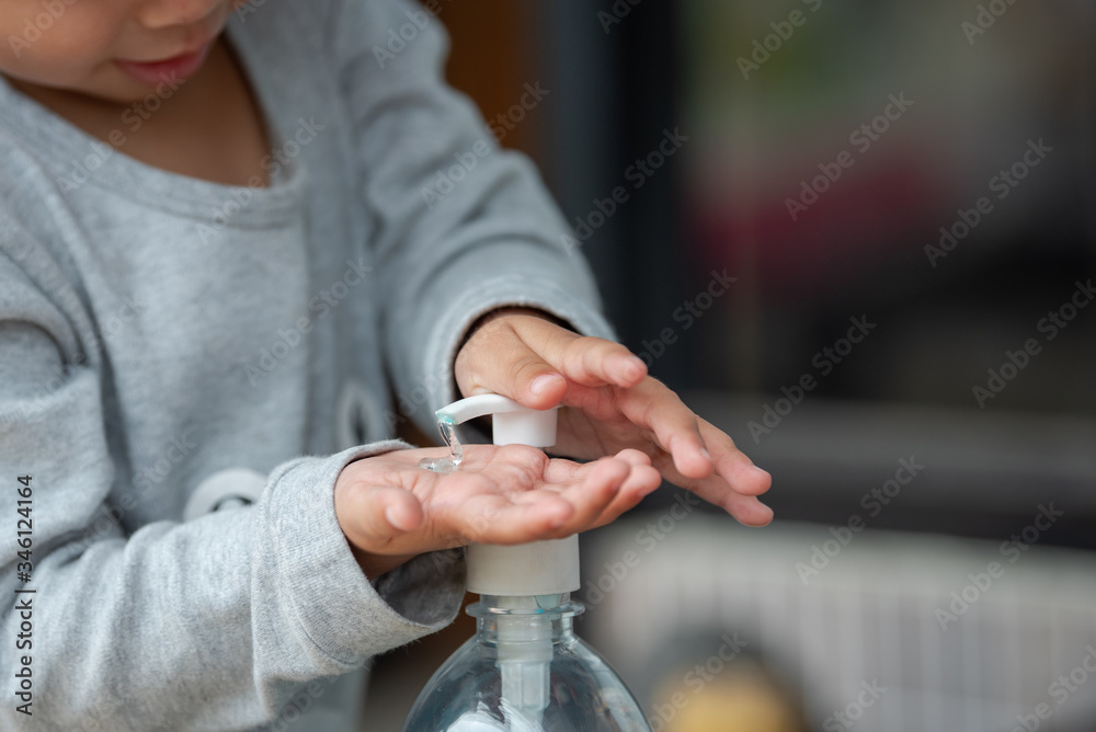 Obraz premium Child Using Hand Sanitizer.