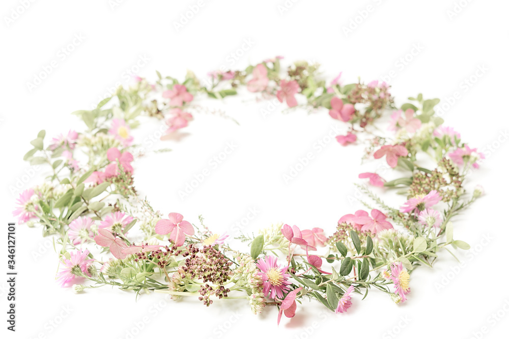 Beautiful and tender wreath frame with pink daisies, heath, branches and leaves on isolated white background. Backdrop for your design. Top view. Copy space.
