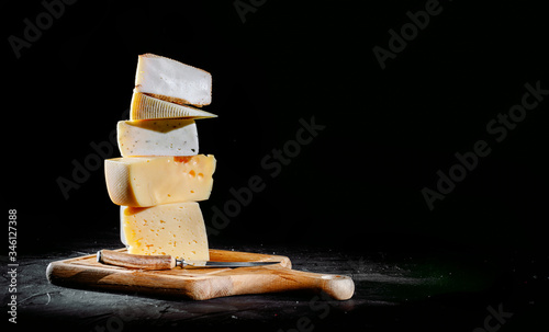 Different sorts of cheese. Сheese delicatessen on a black concrete background