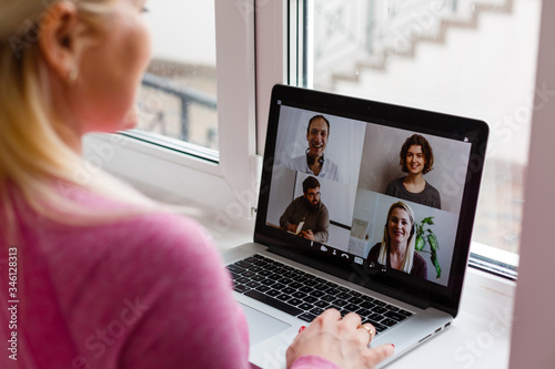 Woman Working From Home Having Group Videoconference On Laptop photo