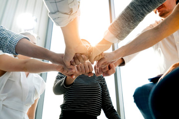 Close up top view of young and freshness energy business people putting their strong hands together. Stack of friendship hands. Unity and successful teamwork concept.
