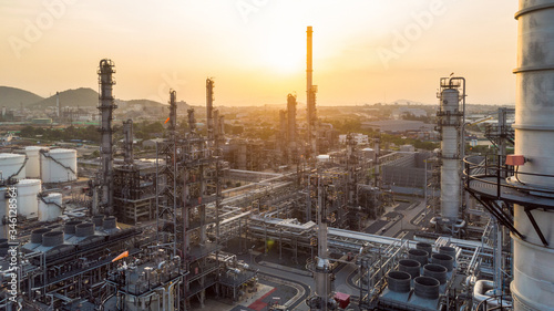 Aerial view of chemical oil refinery plant, power plant and metal pipe on sunrise sky background.