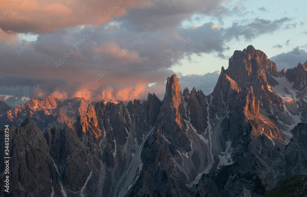 Mountain landscape in the European Dolomite Alps underneath the Three Peaks with alpenglow during sunset, coloured clouds in the sky, South Tyrol Italy.