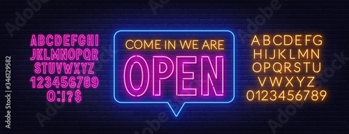 Come in we are open neon sign. Neon alphabet on brick wall background. Vector illustration. photo