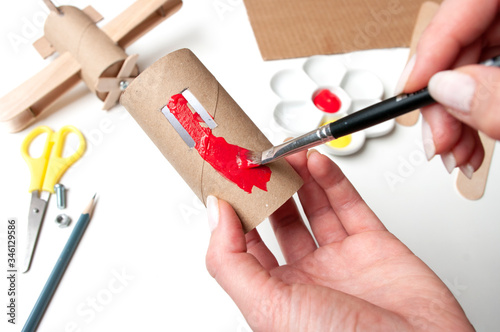 How to make airplane. Hand made toy,zero waste from toilet paper roll and popsicle sticks. For kids and parents. Step 6, paint bigest detail in red color. photo