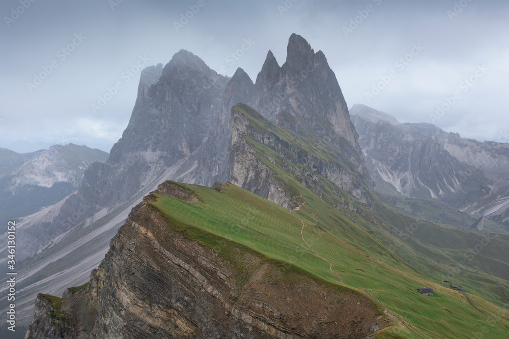 Obraz premium Dramatic weather with rain clouds at mountain peaks and steep cliffs of Seceda in the European Dolomite Alps, South Tyrol Italy.