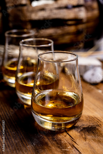 Speyside scotch whisky tasting on old dark wooden vintage table with barley grains