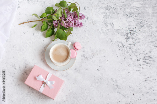 flat lay coffee Cup a sprig of lilac and a gift pink box. Good morning background, place for text