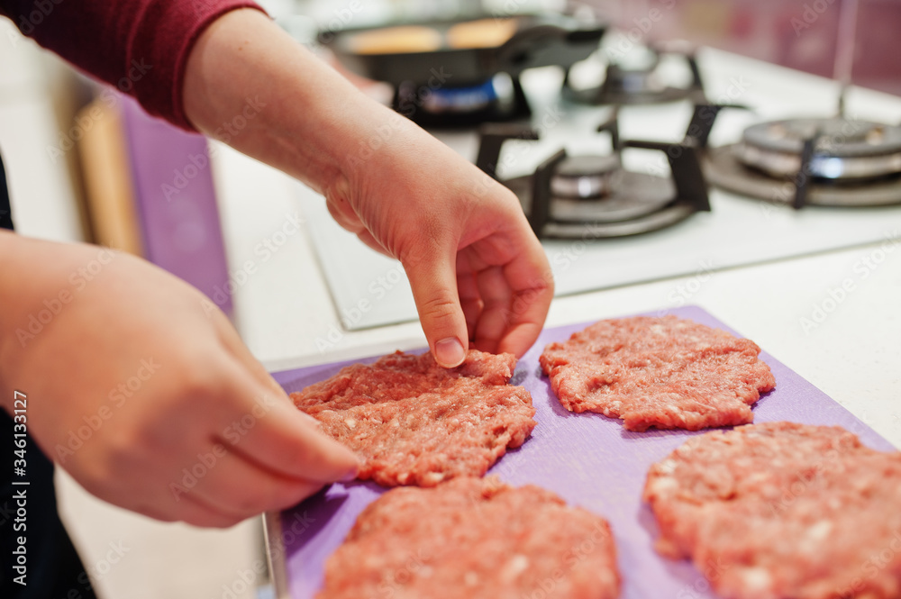 Сooking burgers in the kitchen at home during quarantine time.