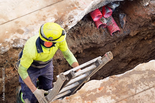 Фотография construction worker for restoir and repair pipes for underground electrical wiri