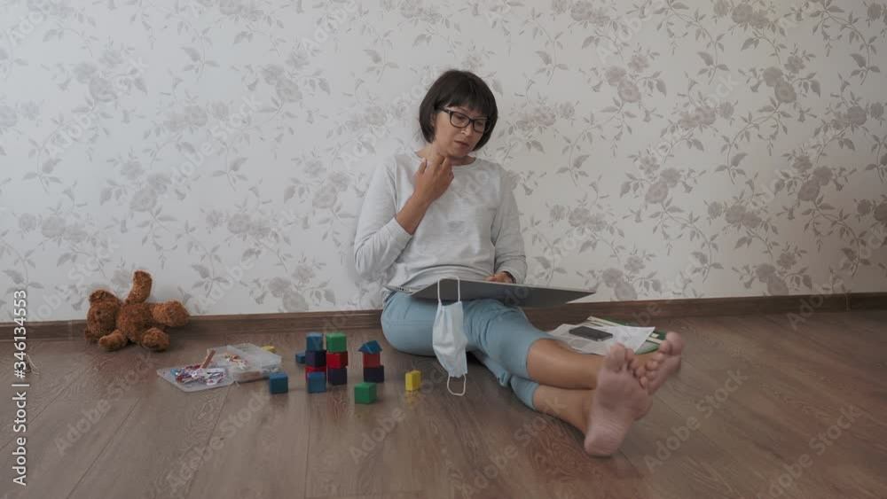 Mom and son sit at home quarantine because of coronavirus COVID19. Mother works remotely among with toys. Self isolation at home.