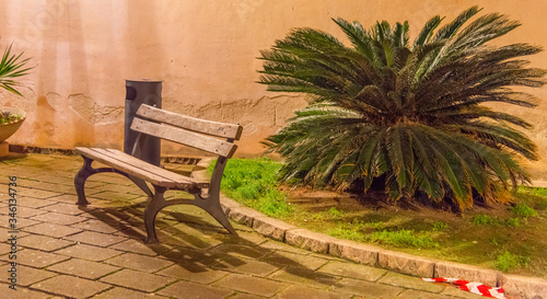 Wooden bench in old town Alghero at night