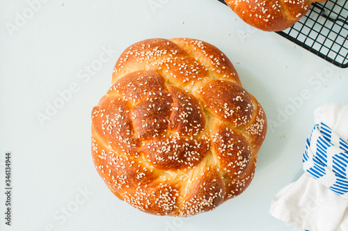 Homemade round challah with sesame seeds. Traditional jewish pastry.