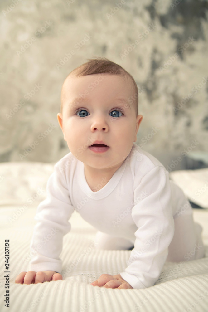 The kid with blue eyes on a white plaid is looking at the camera. The kid with blue eyes on a white plaid is looking at the camera.