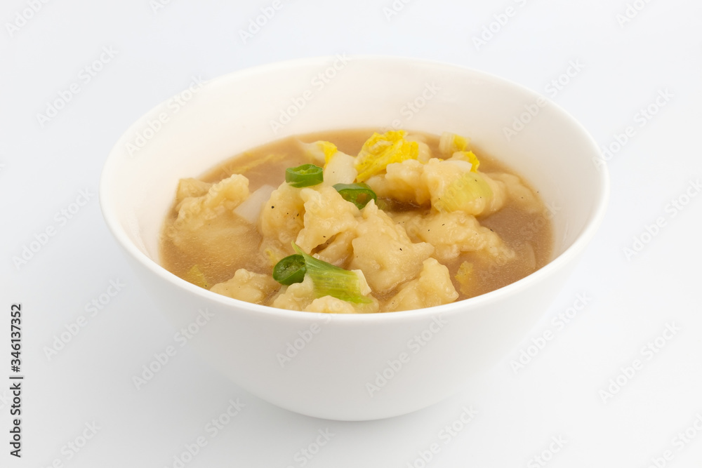 A dish of simmered dough with a background