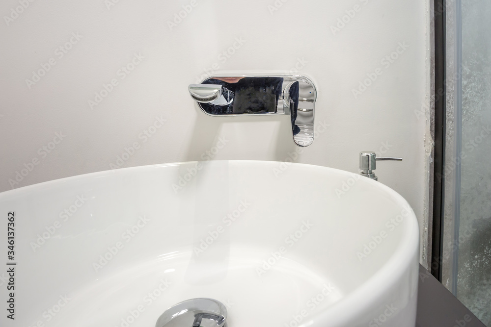 water tap sink with faucet in expensive loft bathroom. detail of a corner shower cabin with wall mount shower attachment water tap sink with faucet in expensive loft bathroom. detail of a corner shower cabin with wall mount shower attachment
